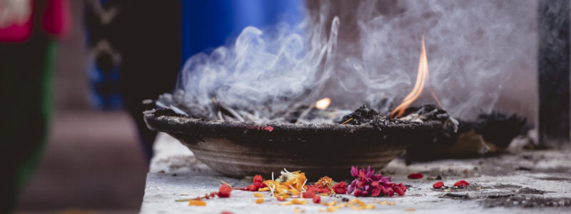 closeup-shot-flower-petals-burning-metal-bowl-ceremony